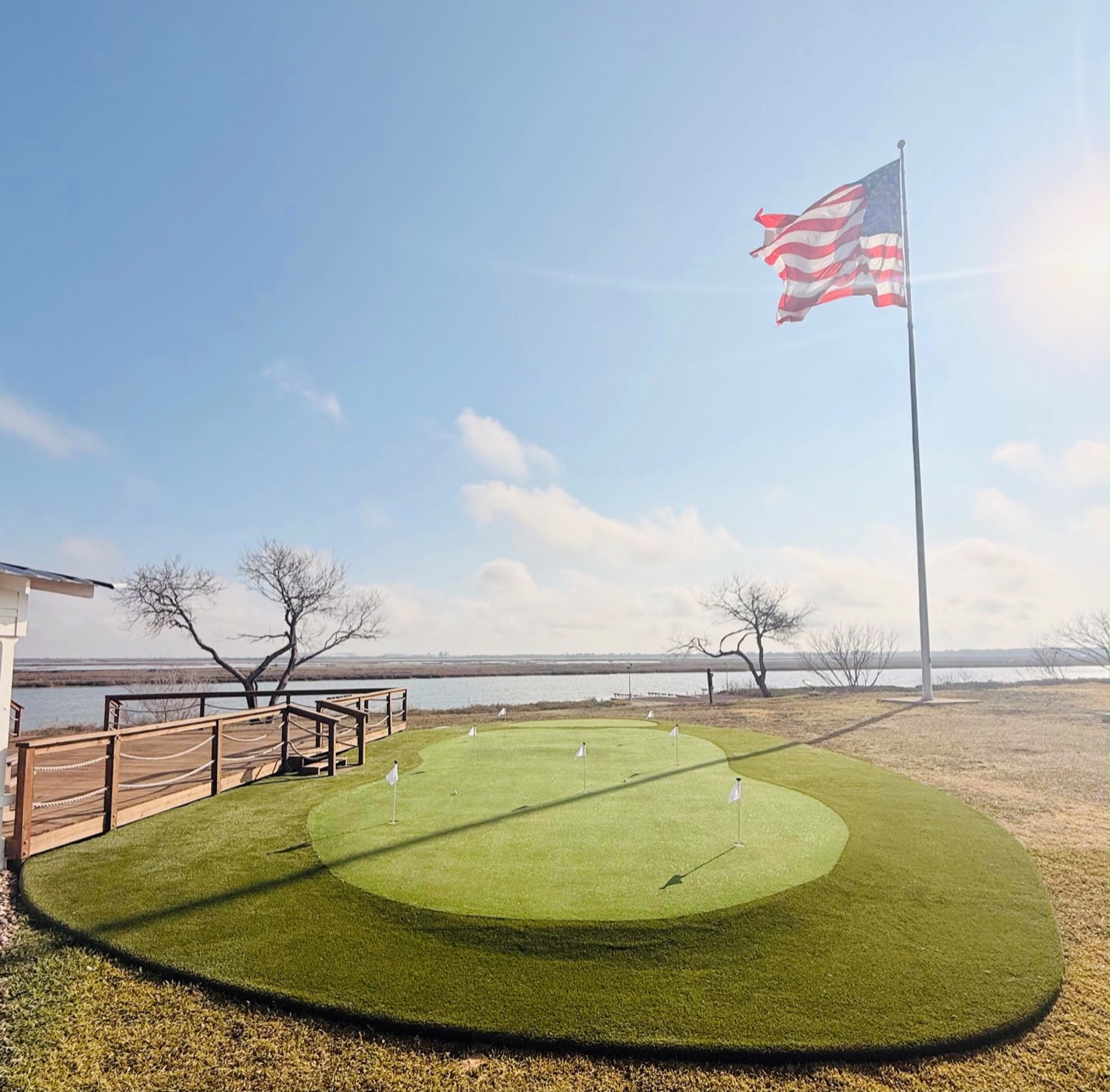 Putting green de golf en casa junto al lago